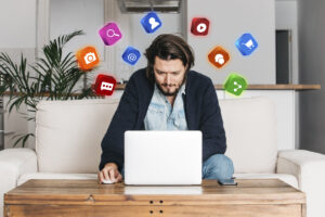 Fiatal férfi ül egy íróasztalnál, laptop előtt dolgozik – digitális marketinggel foglalkozik, a Konverzió Pro Meta Ads kampányait kezeli.